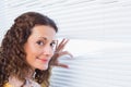 Curious woman looking through blinds Royalty Free Stock Photo