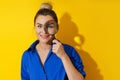 Curious woman is peering through magnifying glass with great interest, examining something closely