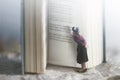 Curious woman reads a giant book