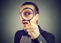 Curious young business man looking through a magnifying glass Royalty Free Stock Photo