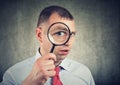 Curious young businessman looking through a magnifying glass Royalty Free Stock Photo