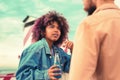 Curious young girl holding bottle and listening attentively to young man