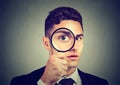 Curious young man looking through a magnifying glass Royalty Free Stock Photo