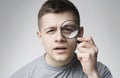 Curious young man looking through magnifying glass Royalty Free Stock Photo