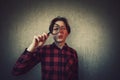 Curious young man looking through the magnifying glass isolated on grey wall background. Surprised young man student found Royalty Free Stock Photo