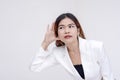 A curious young woman eavesdropping with palms open next to her ear. Isolated on a white background Royalty Free Stock Photo