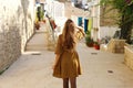 Curious young woman walking in old street of Alicante, Spain. Rear view of happy cheerful girl visiting southern Europe Royalty Free Stock Photo