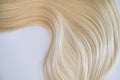 Curl female healthy hair. Concept hairdresser spa salon. strand of blond silky hair on a white background. Royalty Free Stock Photo