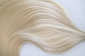 Curl female healthy hair. Concept hairdresser spa salon. strand of blond silky hair on a white background.