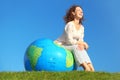 Curl woman sitting on inflatable globe