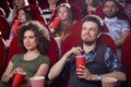 Curled woman and man with beard at cinema. Royalty Free Stock Photo