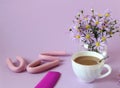 Curler for Curling hair, comb with a Cup of coffee and a bouquet of chrysanthemums , side view, pastel background - the concept of