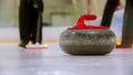 Curling training - a granite stone with red handle on the ice field Royalty Free Stock Photo