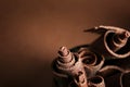 Curls of tasty dark chocolate against color background Royalty Free Stock Photo