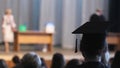 Curly alumnus in graduation cap watching ceremony, step in a happy future