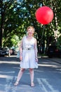 Curly blond girl with big red ballon Royalty Free Stock Photo