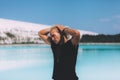 Curly blond man posing at the clear beach. Dressed all black. Awesome background, clear water and sky. Trendy, tropical and