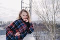 Curly blond pretty young woman in poncho in winter park. Cold weather. Holidays, season and leisure concept. Christmas Royalty Free Stock Photo