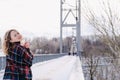 Curly blond pretty young woman in poncho in winter park. Cold weather. Holidays, season and leisure concept. Christmas Royalty Free Stock Photo