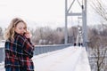 Curly blond pretty young woman in poncho in winter park. Cold weather. Holidays, season and leisure concept. Christmas Royalty Free Stock Photo