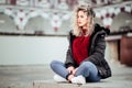 Curly blonde woman sitting on bech. Casual clothes