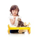 Curly child girl playing with kitten