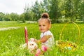 Curly cute girl with rabbit in green park