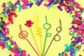 Curly drinking straws on yellow background surrounded by confetti. Drinking straw day concept