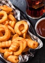 Curly fries fast food snack in red plastic tray with glass of cola and ketchup on stone kitchen background. Unhealthy junk food