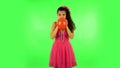 Curly girl inflates a bright red ball then rejoicing. Green screen