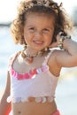 Curly girl pink dress with shell decorations on the beach