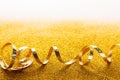 Curly golden serpentine on glitter background Royalty Free Stock Photo
