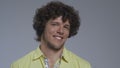 Curly guy hears the music and moves his head to the tact. Portrait of a dancing man. High quality