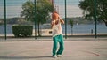 Curly guy playing basketball on sports field. Skilful teenager throwing ball