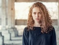 Curly hair. Beautiful girl on background of an abandoned concrete building. Light from behind at the industrial area Royalty Free Stock Photo