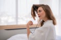 Curly Hair. Beautiful Smiling Woman With Long Blonde Wavy Hair Ironing It, Using Curling Iron. Happy Girl With Gorgeous Healthy Royalty Free Stock Photo