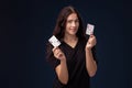 Curly hair brunette is posing with playing cards in her hands. Poker concept on a black background. Casino. Royalty Free Stock Photo