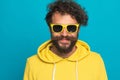 Curly hair guy in yellow sweatshirt with glasses smiling and posing Royalty Free Stock Photo