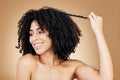 Curly, hair and strand of woman in studio for natural beauty, healthy growth and coil textures on brown background