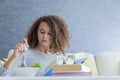 Curly hair teen girl reading book and eating salad Royalty Free Stock Photo