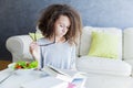 Curly hair teen girl reading book and eating salad Royalty Free Stock Photo