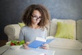 Curly hair teen girl reading book and eating salad Royalty Free Stock Photo