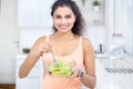 Curly hair woman eating a bowl of tasty salad