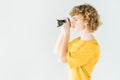 Curly hair young photographer looks through the camera