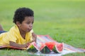 Curly-haired black boy eating lollipops lying on mat with toys on holiday Royalty Free Stock Photo