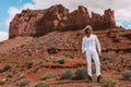 A curly haired blonde man posing around the famous Buttes of Monument Valley from Arizona, USA, wearing white linen shirt and Royalty Free Stock Photo