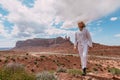 A curly haired blonde man posing around the famous Buttes of Monument Valley from Arizona, USA, wearing white linen shirt and Royalty Free Stock Photo