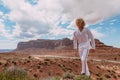 A curly haired blonde man posing around the famous Buttes of Monument Valley from Arizona, USA, wearing white linen shirt and Royalty Free Stock Photo