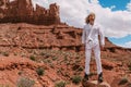 A curly haired blonde man posing around the famous Buttes of Monument Valley from Arizona, USA, wearing white linen shirt and Royalty Free Stock Photo