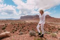 A curly haired blonde man posing around the famous Buttes of Monument Valley from Arizona, USA, wearing white linen shirt and Royalty Free Stock Photo